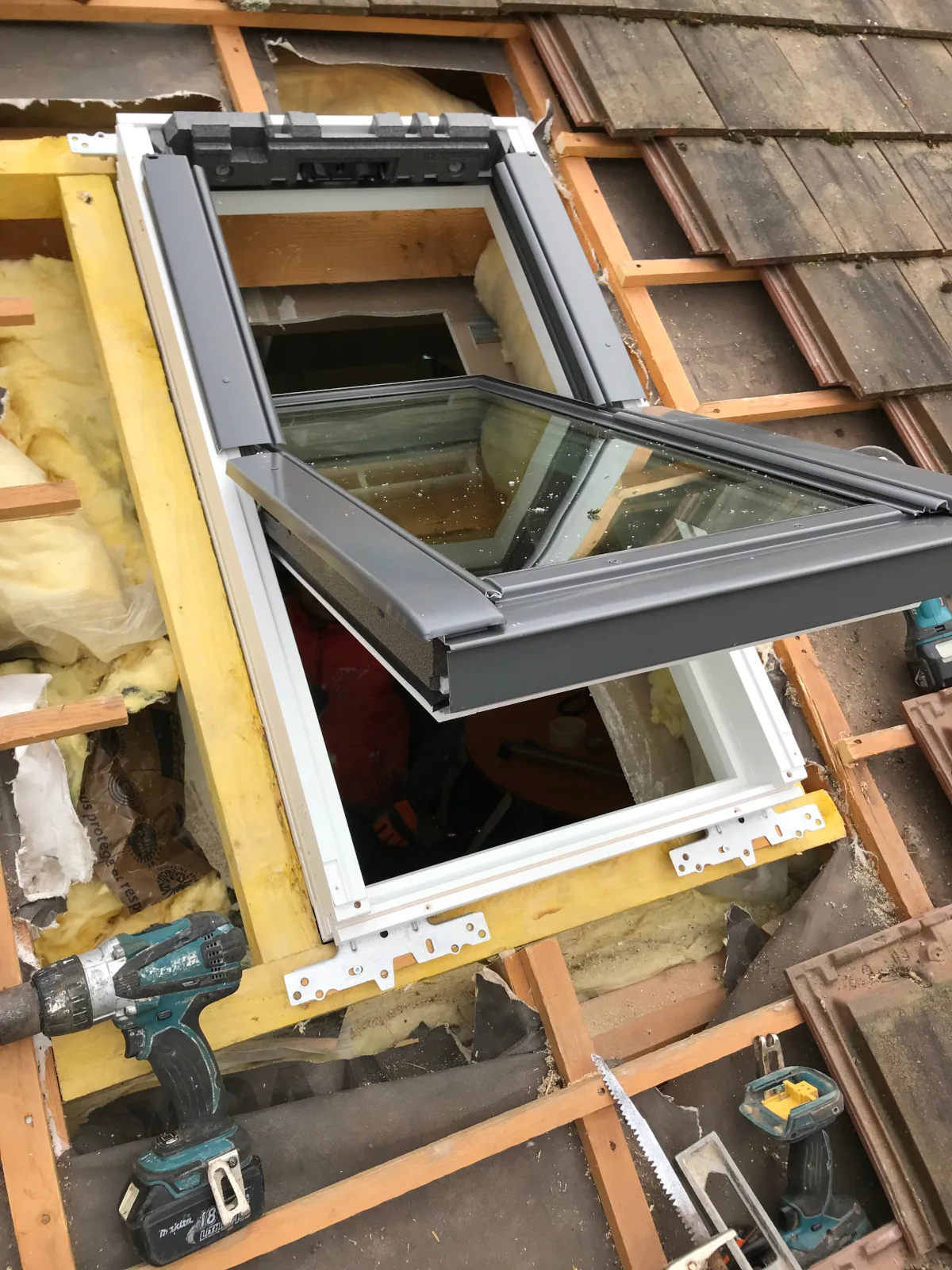 Couvreur Lafleur Couvreur posant un Velux pendant une rénovation de toiture en Seine-et-Marne