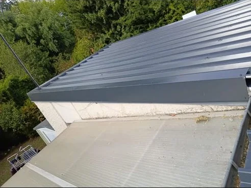 Couverture neuve en bac acier posée à côté d'anciennes plaques de fibrociment ondulé, en Seine-et-Marne