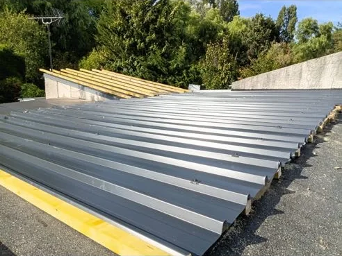 Chantier de couverture en cours à Roissy-en-Brie : bacs acier posés et contre-lattage bois encore visible