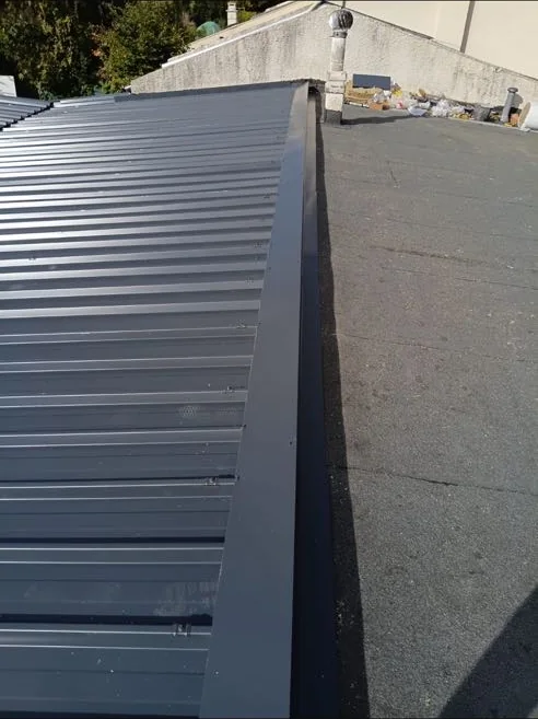 Finition de rive latérale en profilé laqué sur une couverture en bac acier
